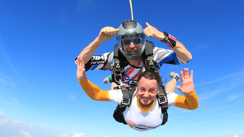 Woman in Treetops t-shirt on tandem parachute jump