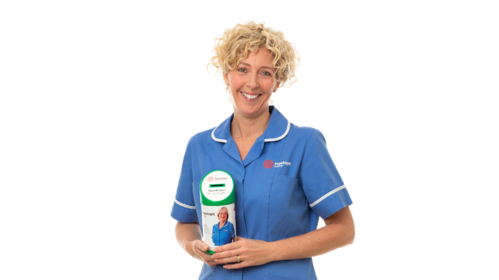 A Treetops nurse holding a collection tin and smiling