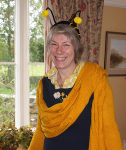 Smiling woman dressed as a bee with headband and yelllow shawl