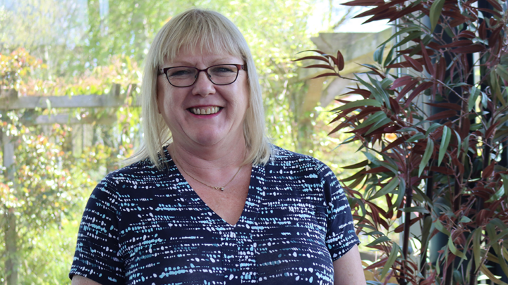 An image of a blonde haired woman staring at the camera smiling