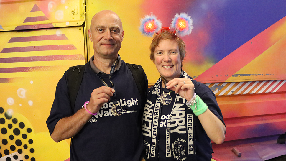 Brother and sister dressed in Moonlight Walk t-shirts holding up medals and smiling