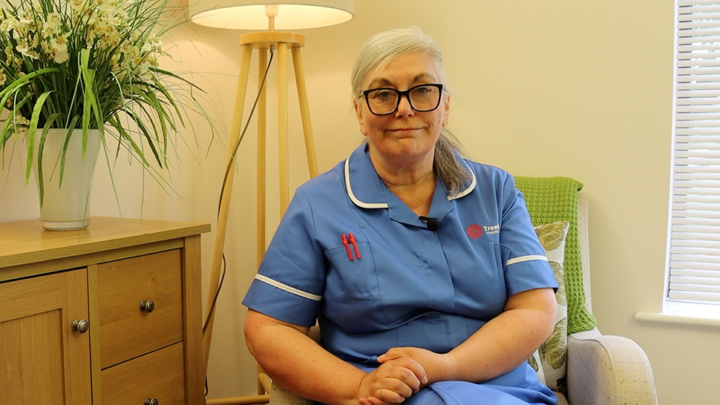 Treetops Hospice nurse in a blue nurse uniform smiling