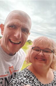 Couple in the countryside taking a selfie and smiling at the camera