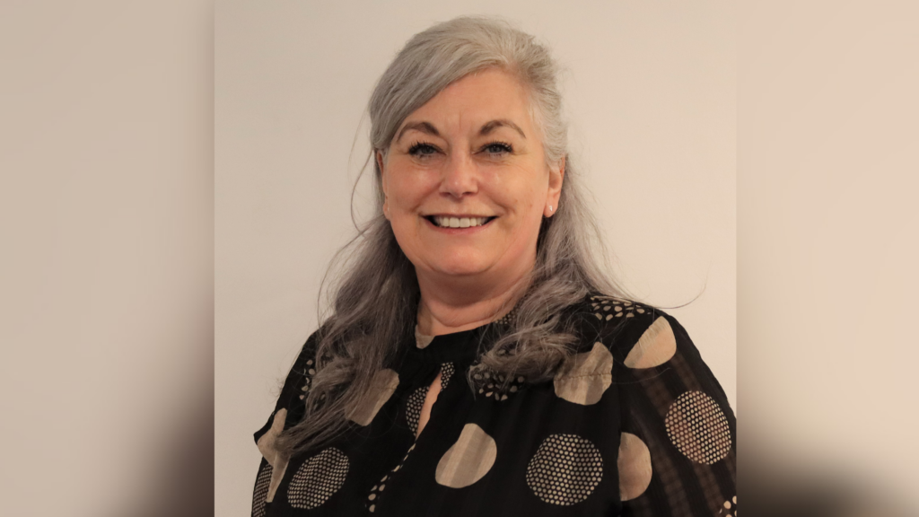 Lady with long grey hair in a spotty dress